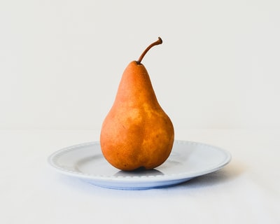 橙色梨在白色的陶瓷板
